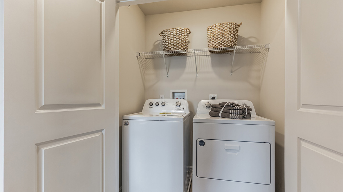 Laundry room with with washer and dryer and shelf above.