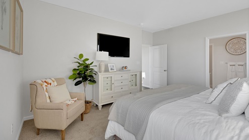 The primary bedroom with a view into the bathroom.
