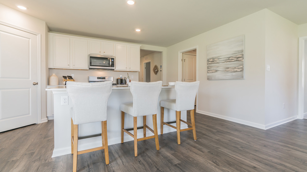 The kitchen's center island with an eat-in kitchen counter and three bar stools.