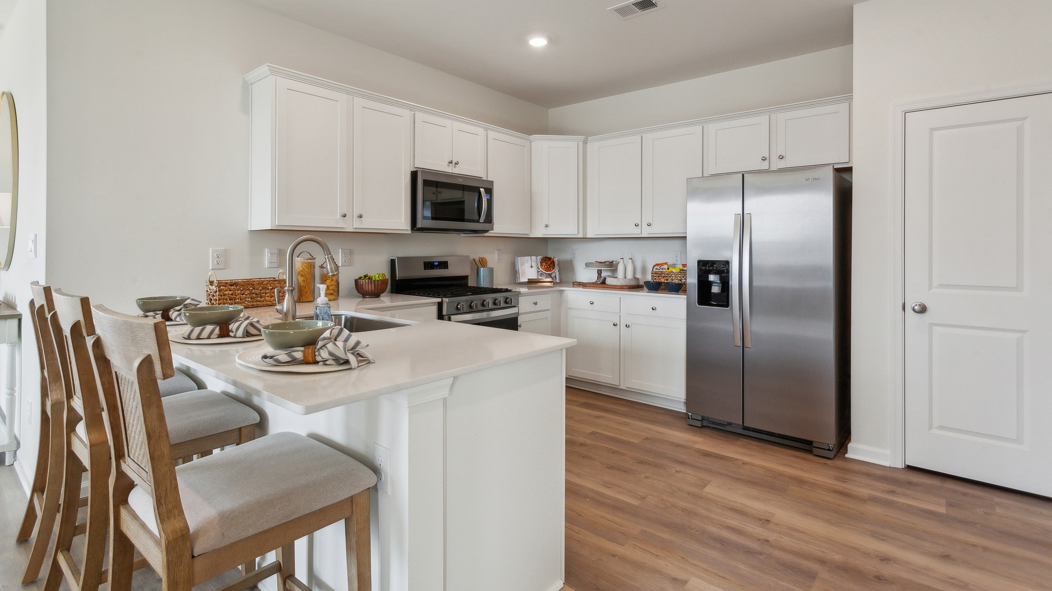 The open-concept kitchen has bright white kitchen cabinets.