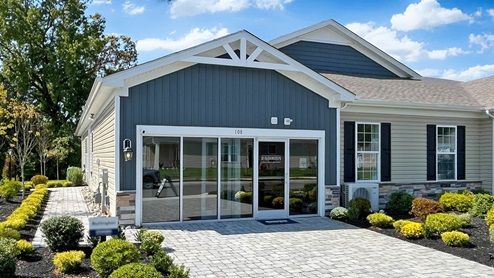 Silver Lake Reserve Burlington plan single-story twin home in wicker color siding, midnight surf board and batten accent siding, and white garage door.