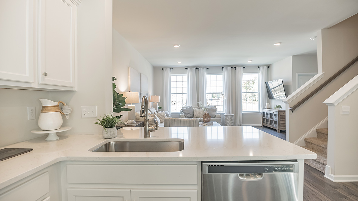 Inside of the kitchen counter seating area with the living area in the back.