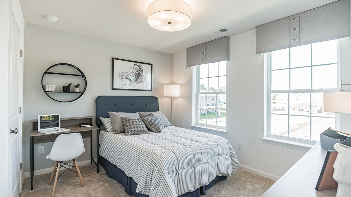 Bedroom three with two windows and closet door.