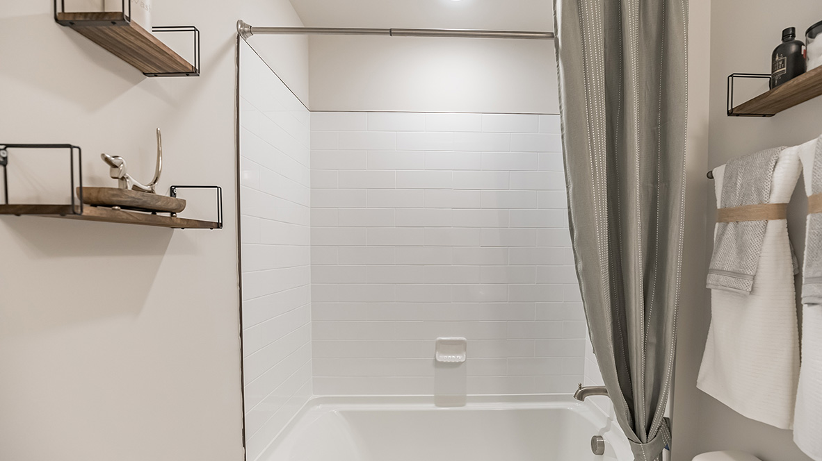 Secondary full bath on the second floor with single sink vanity and shower tub.