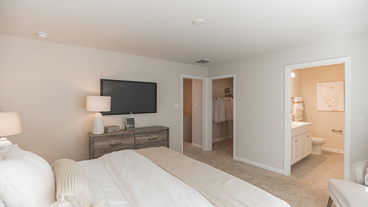 Primary bedroom with a peek into the connecting closet and bathroom.