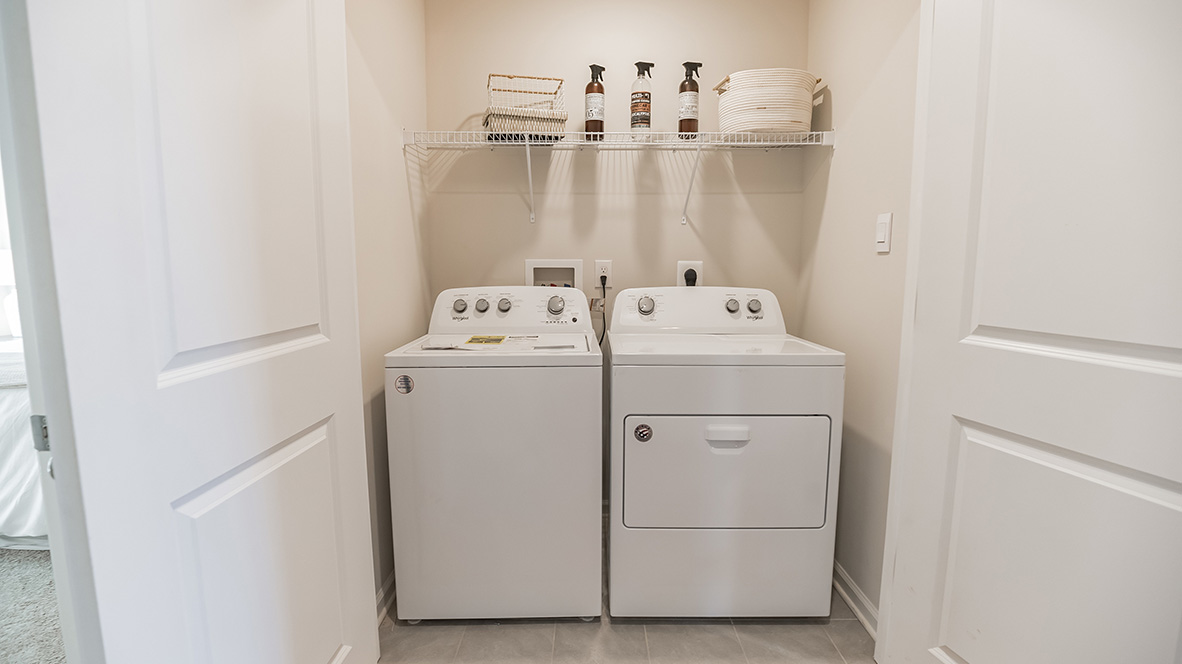 Laundry room with washer and dryer and shelf above.