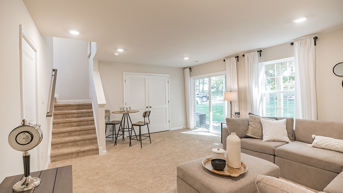 Lower level recreation room with double doors to the utility room and back sliding glass door to the backyard.