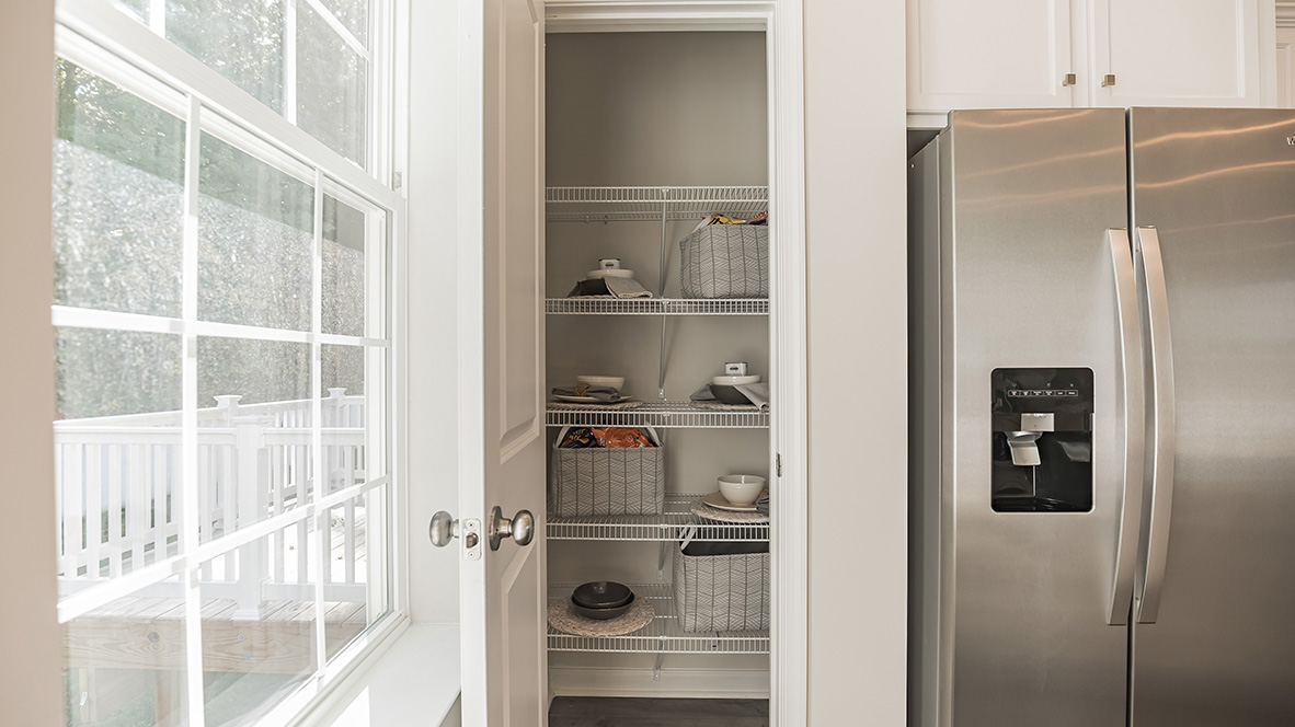 Pantry with shelves next to the fridge.