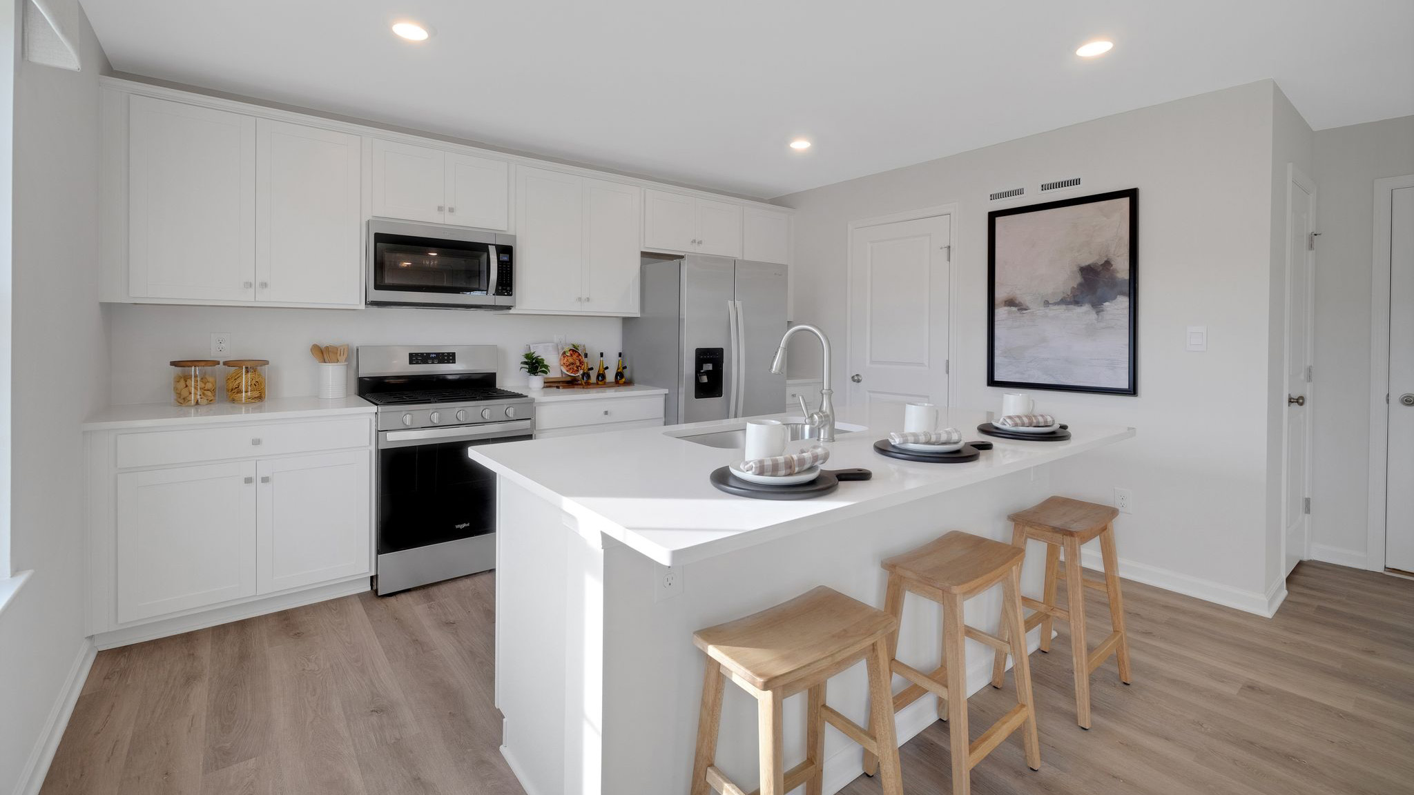 Open-concept kitchen with white cabinets and a large island.