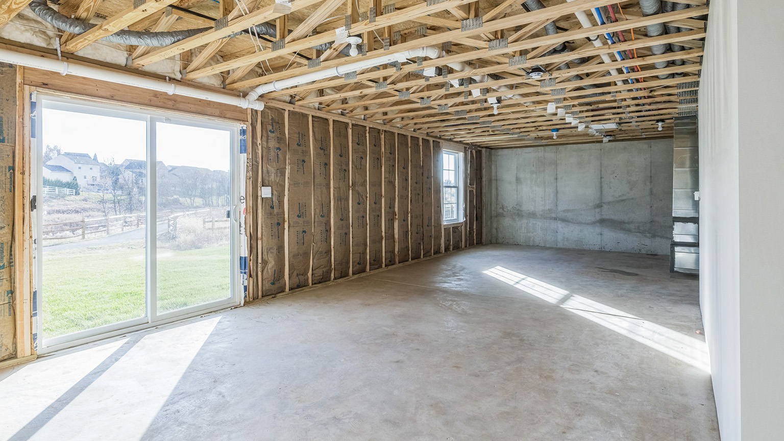 An interior view of the unfinished basement and walkout basement door.