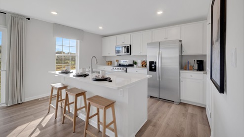 The open kitchen boasts a large island with modern white cabinetry.