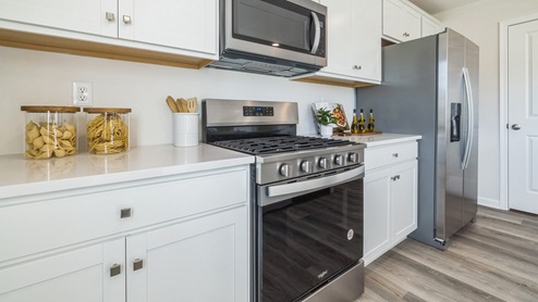 The kitchen offers sleek stainless steel range, microwave, and dishwasher