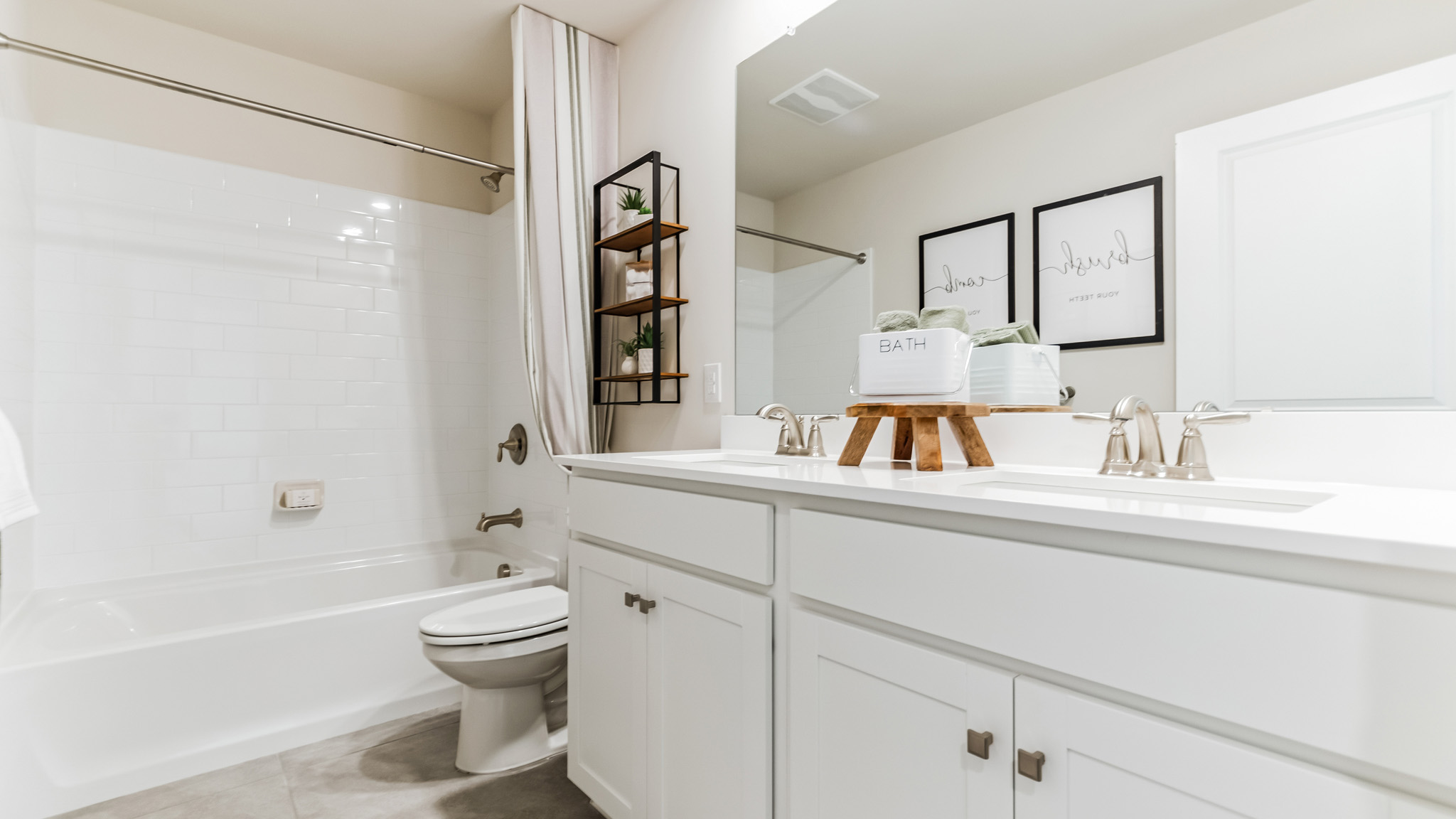 Full bathroom with shower and tub combined. Double sinks with storage below.