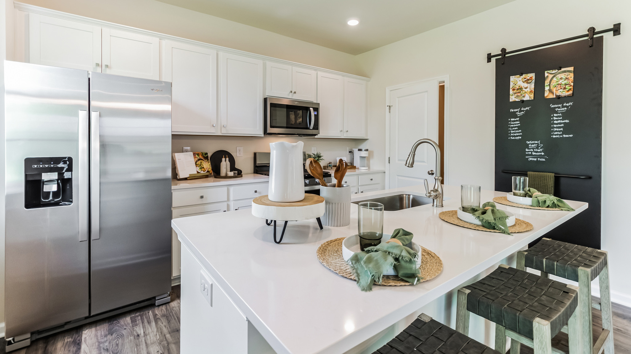 Kitchen with island seating and stainless-steel appliances.