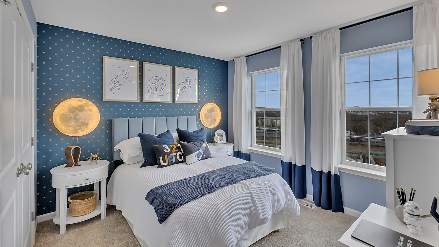 Bedroom two has two large windows and a space astronaut themed design.