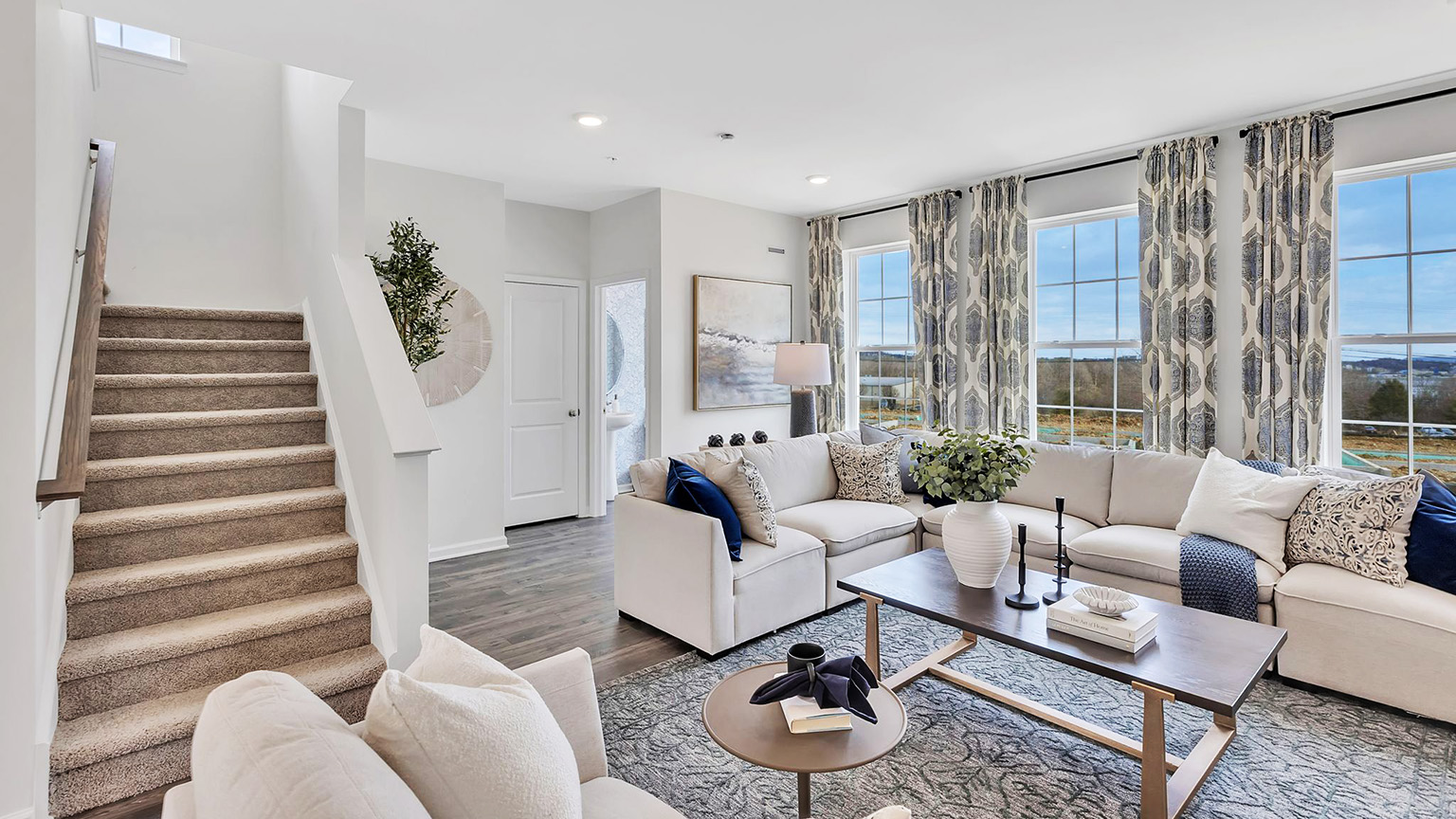Living area with open layout and three large windows.