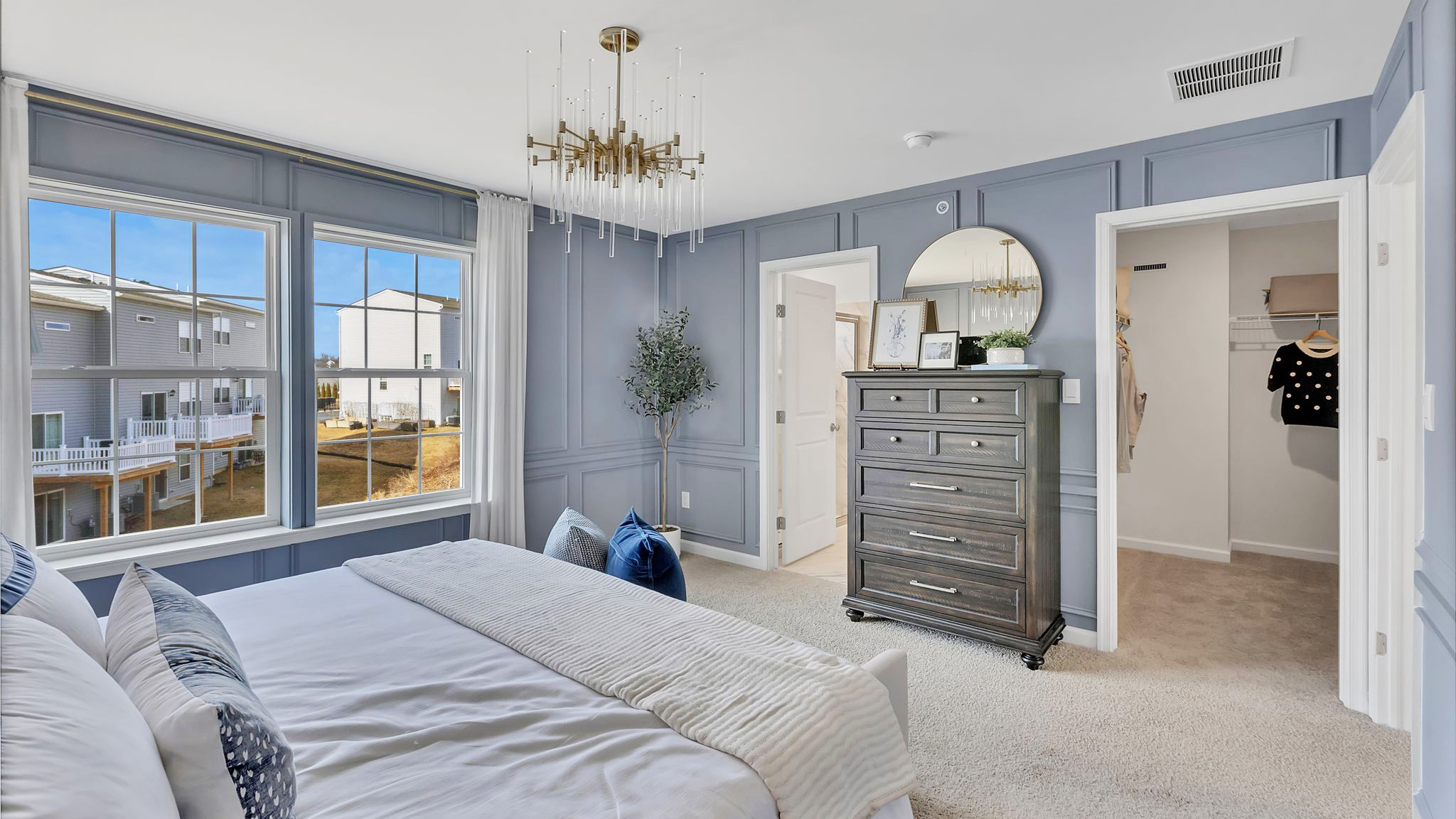 Primary bedroom with with a peek into the connecting closet and bathroom.
