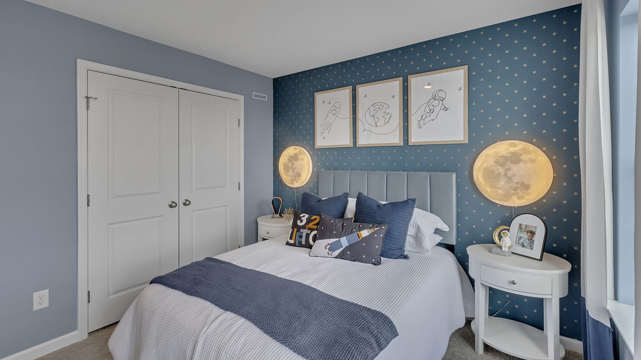 Bedroom two has two large windows and a space astronaut themed design.