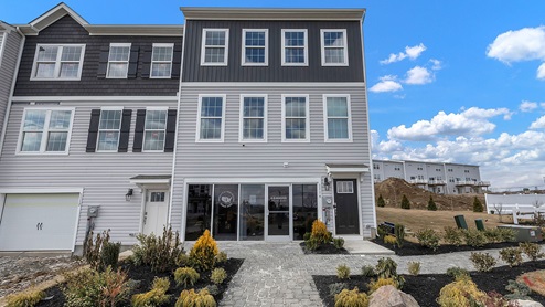A side angle view of Wrenfield model exterior with light gray and dark charcoal gray siding.