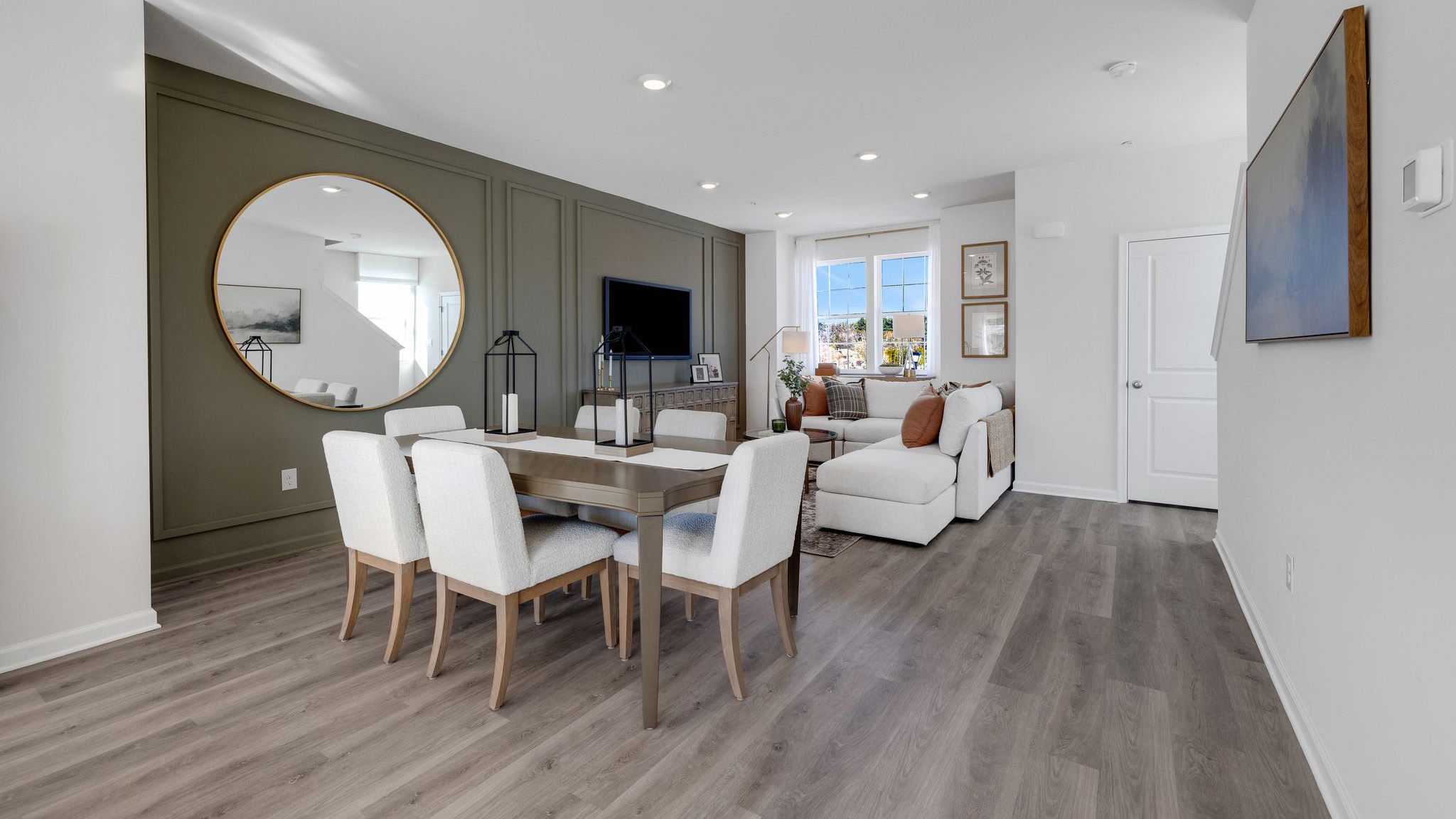 Dining area flows nicely into the large living room area and stairs on the right side of the room and the half bath in the back right.
