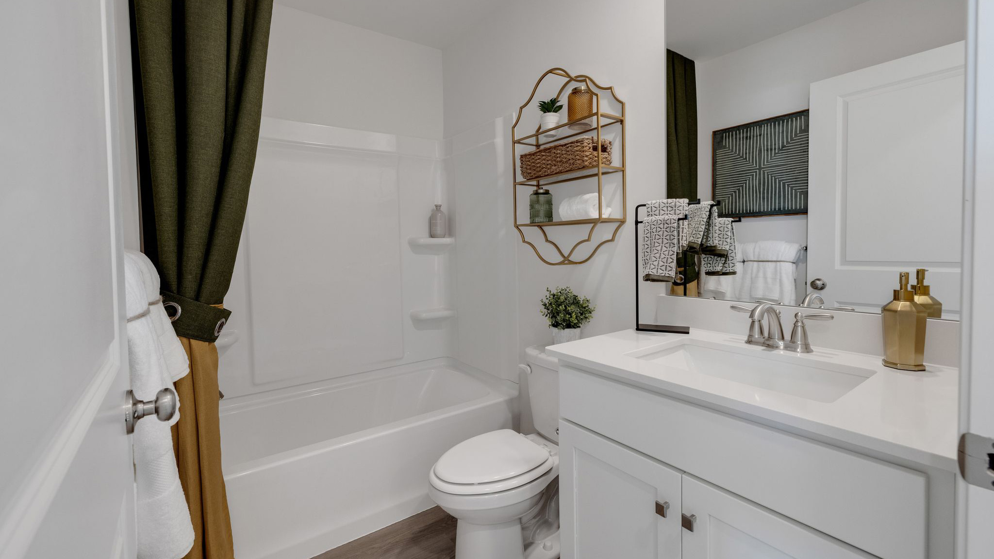 Secondary bathroom with single sink white vanity and tub shower.