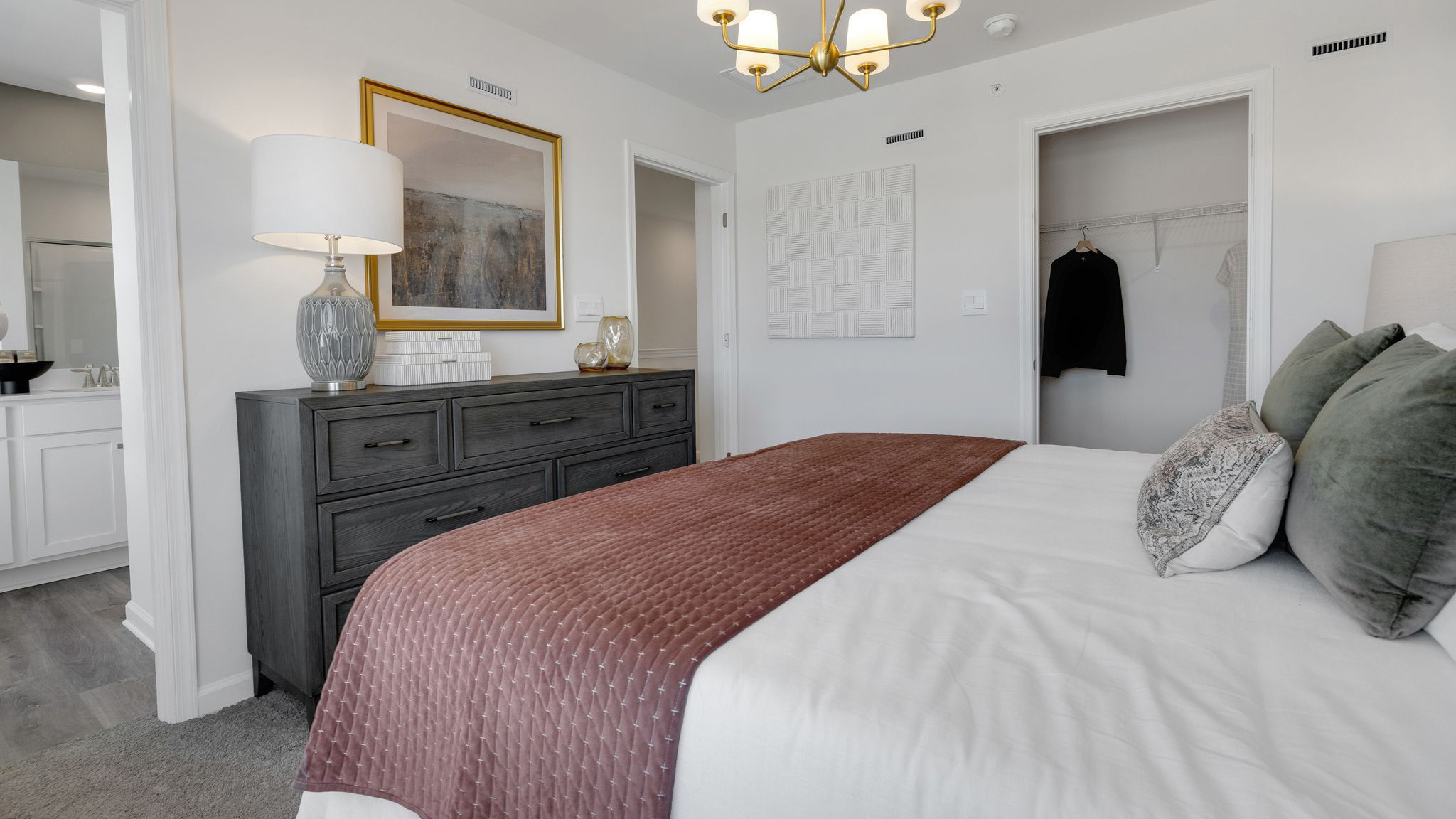Primary bedroom with a peek into the connecting bathroom.