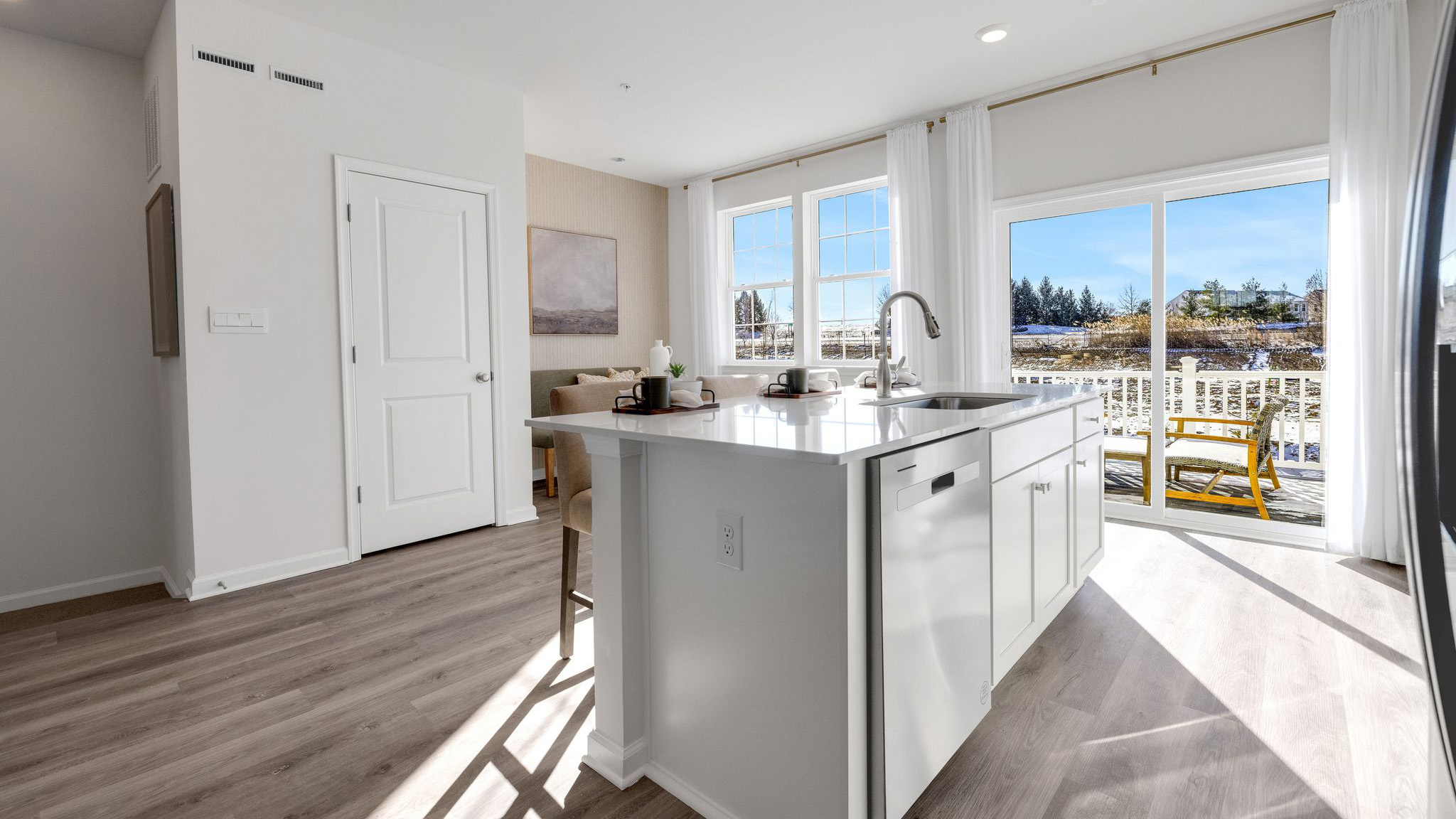 Quartz countertops with dishwasher and sink in the large island and pantry in the back.