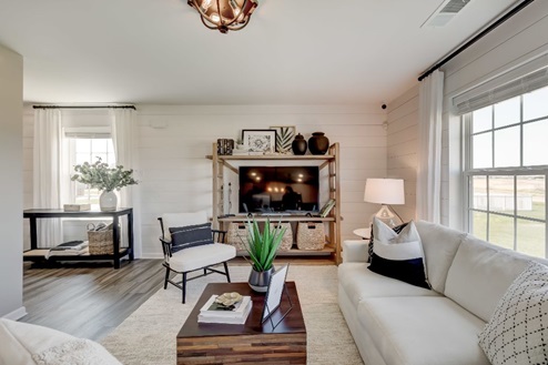 Entertainment center in front of a shiplap wall in the open concept living room.