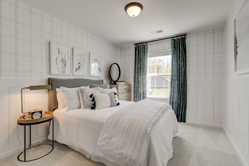 Secondary bedroom with a double bed, window for natural lighting, nightstand, and chest of drawers.
