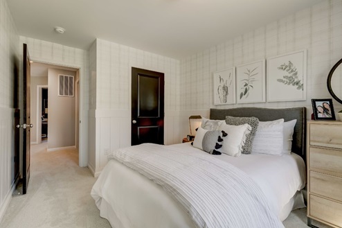 Secondary bedroom with a double bed, nightstand, and chest of drawers.