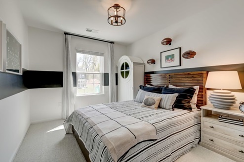 Secondary bedroom with a double bed, nightstand, and storage cabinet plus a window that allows natural light to flow in.