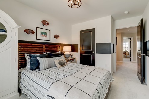 Secondary bedroom with a double bed, nightstand, and storage cabinet.
