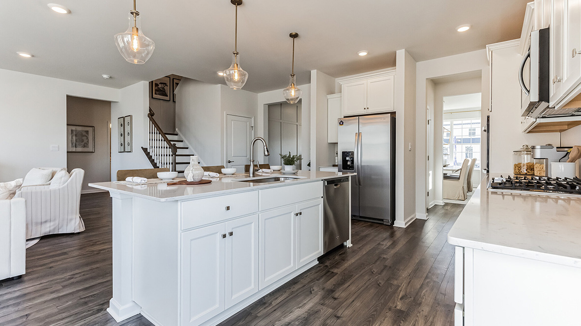 Inside of the kitchen island with a view of the stairs, living area and peek into the dining room.