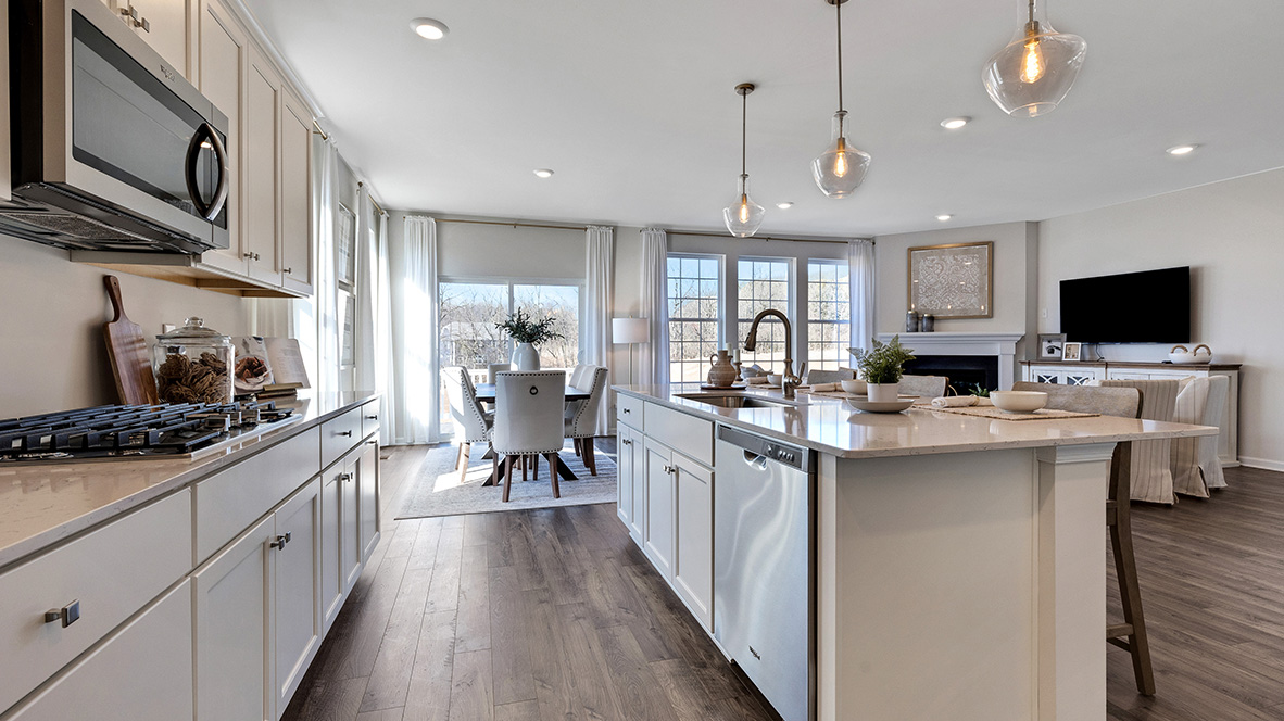The walkway between the kitchen island and the kitchen wall. Casual dining area is behind.