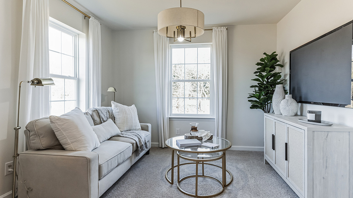 Owners suite sitting area with two large single windows and TV.