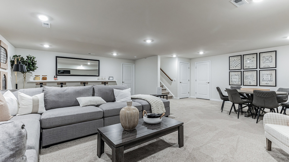 Finished basement or recreation room area with the stairs in the back right corner.