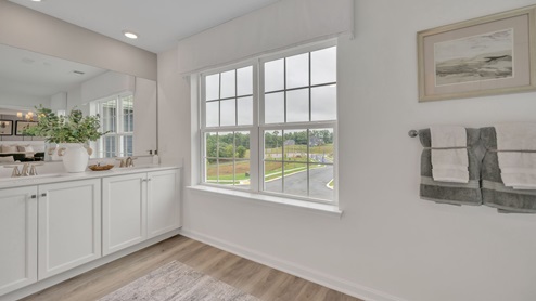 Bathroom with double sinks and large window for natural lighting.