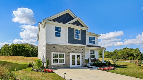 Exterior of the home with blue and cream siding with partial stone.