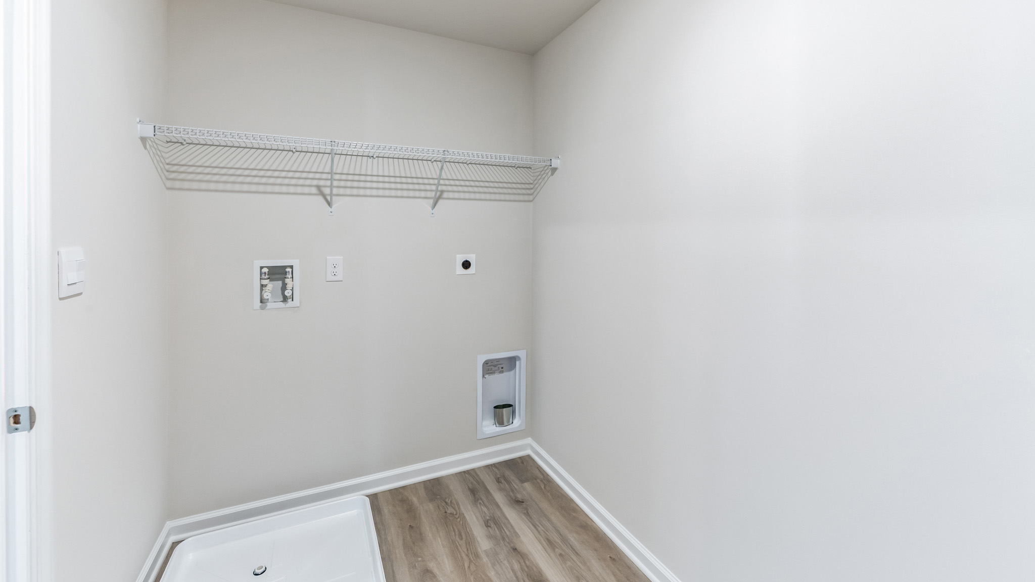 An empty laundry room with hookups for  washer and dryer.