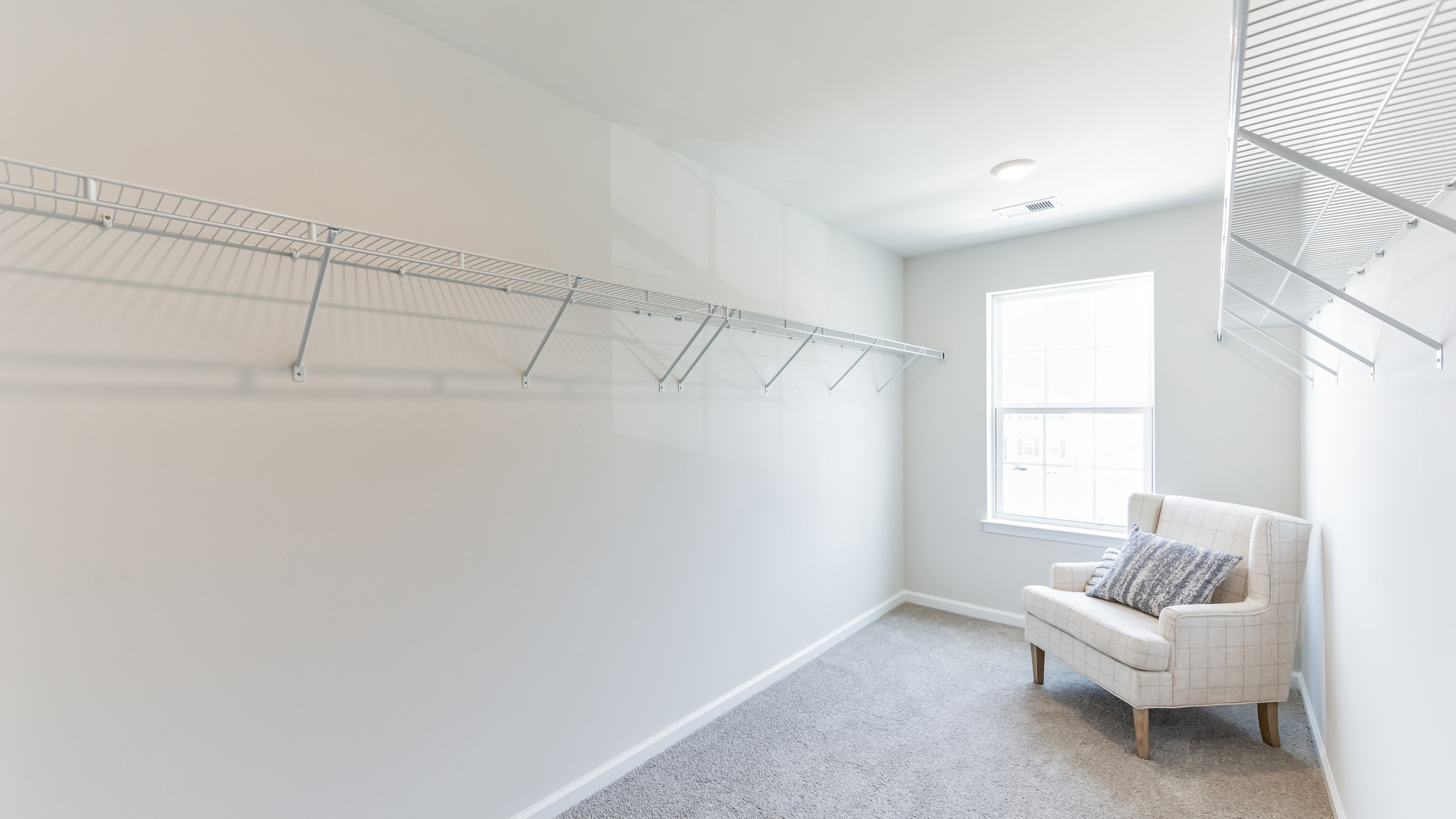 The primary bedroom closet with one window.