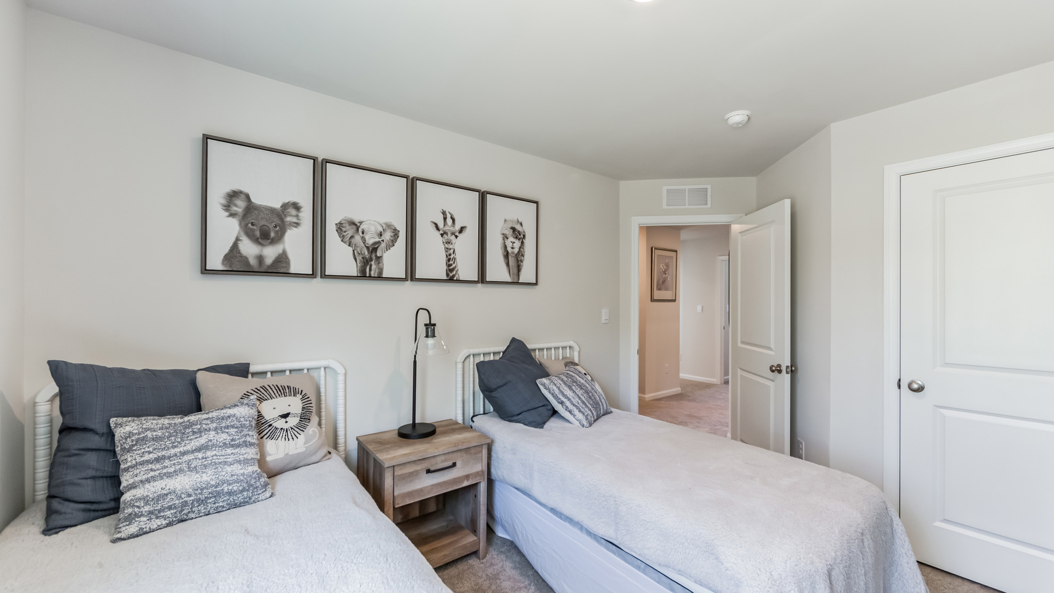 A guest bedroom with two beds and view back towards the upstairs hallway.