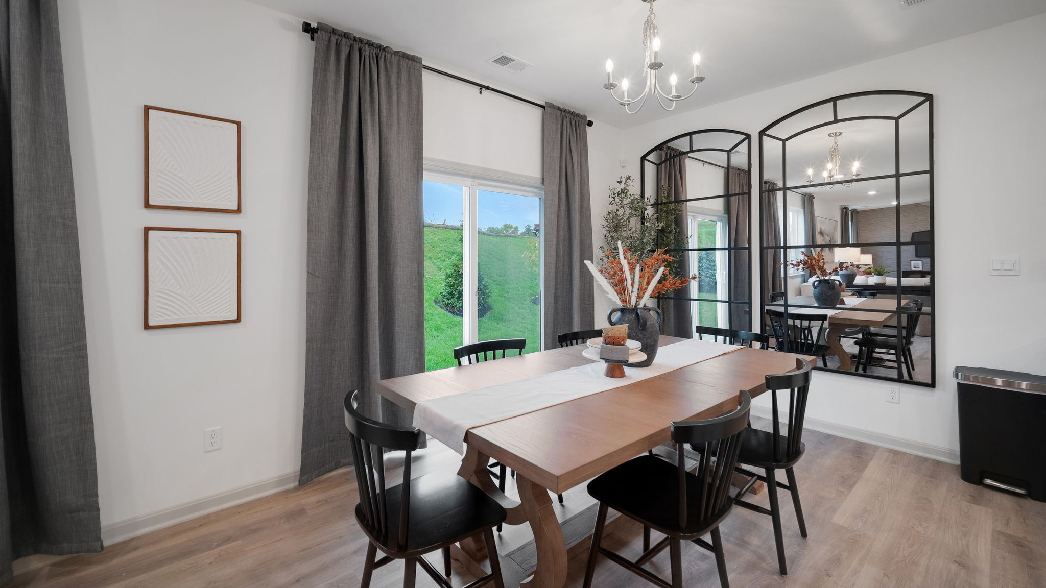 Dining space with a wooden table flanked by six wooden chairs in front of sliding-glass doors allowing access to the back yard.