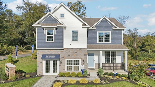 Exterior image of two story home with blue and white siding with brick.