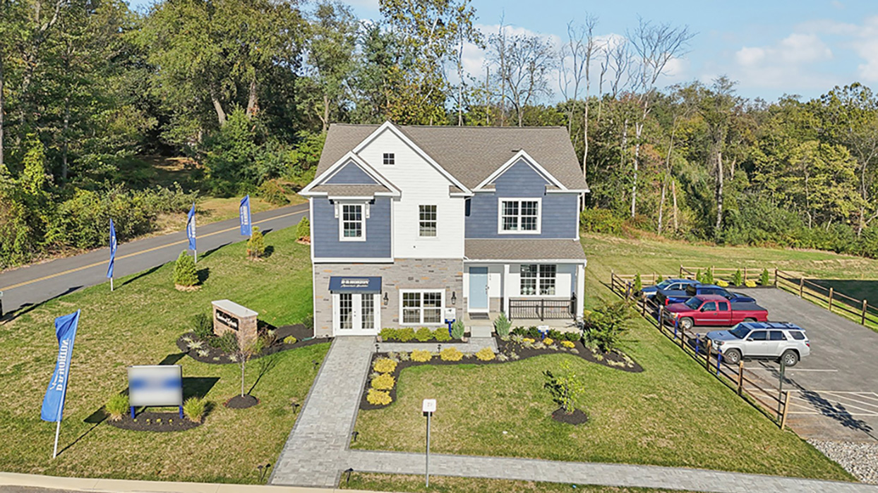 Exterior image of two story home with blue and white siding with brick.