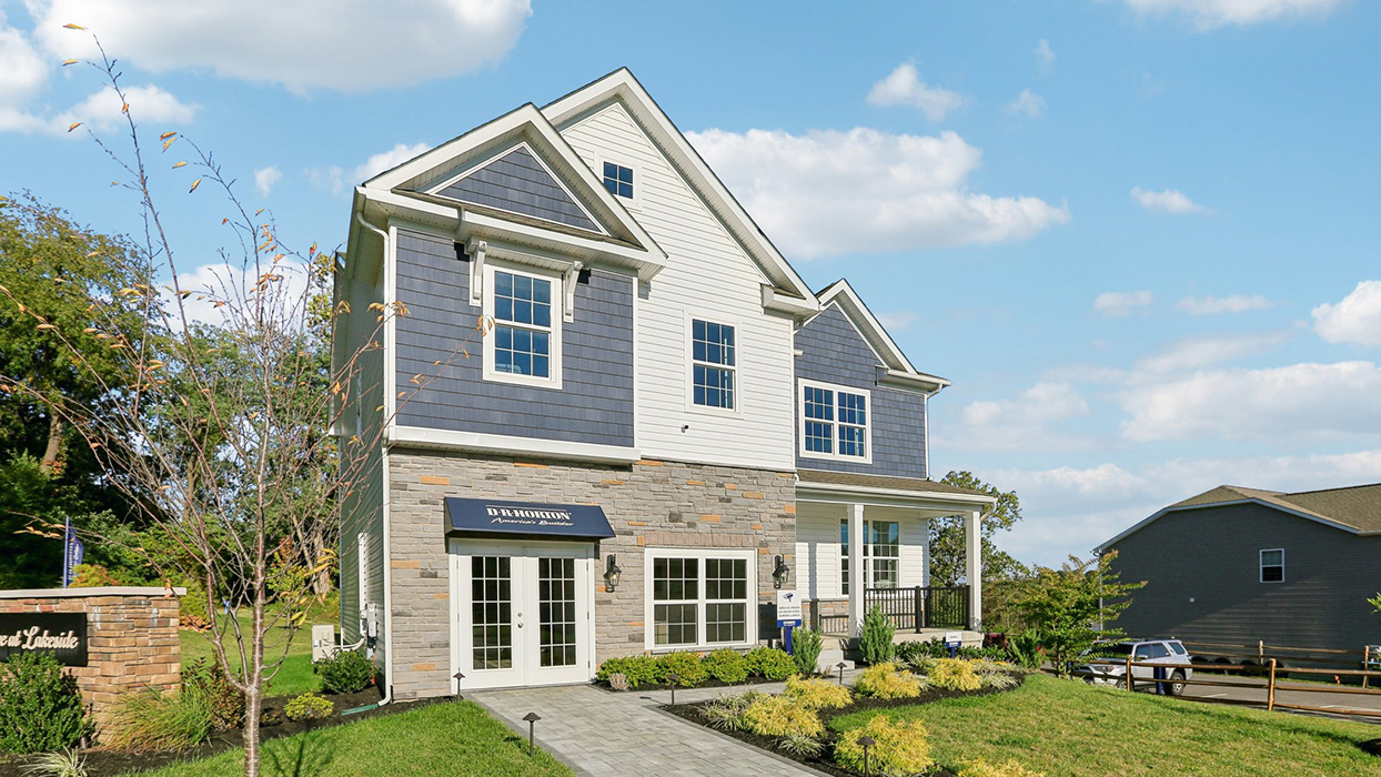 Exterior image of two story home with blue and white siding with brick.