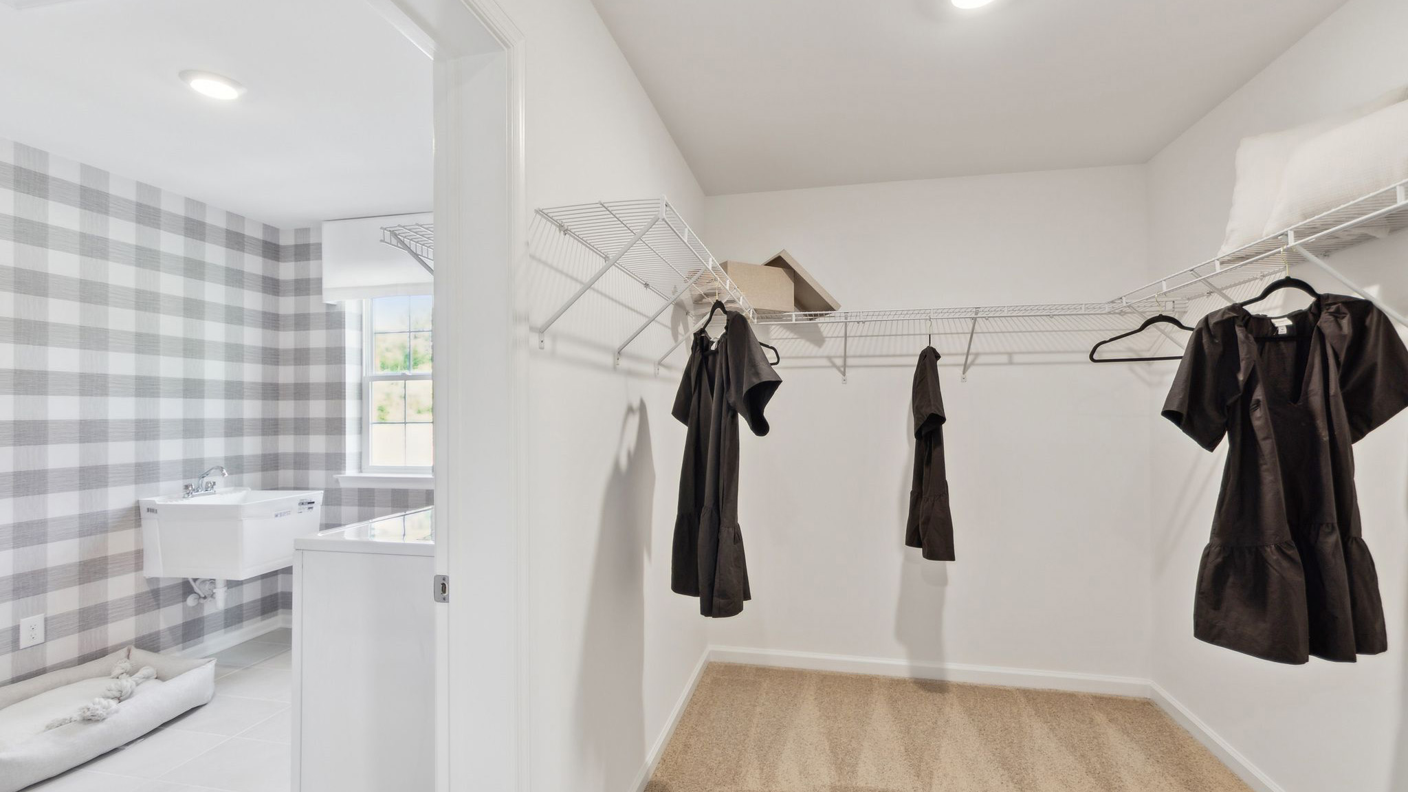 Other side of the large primary closet with peek into the laundry room.