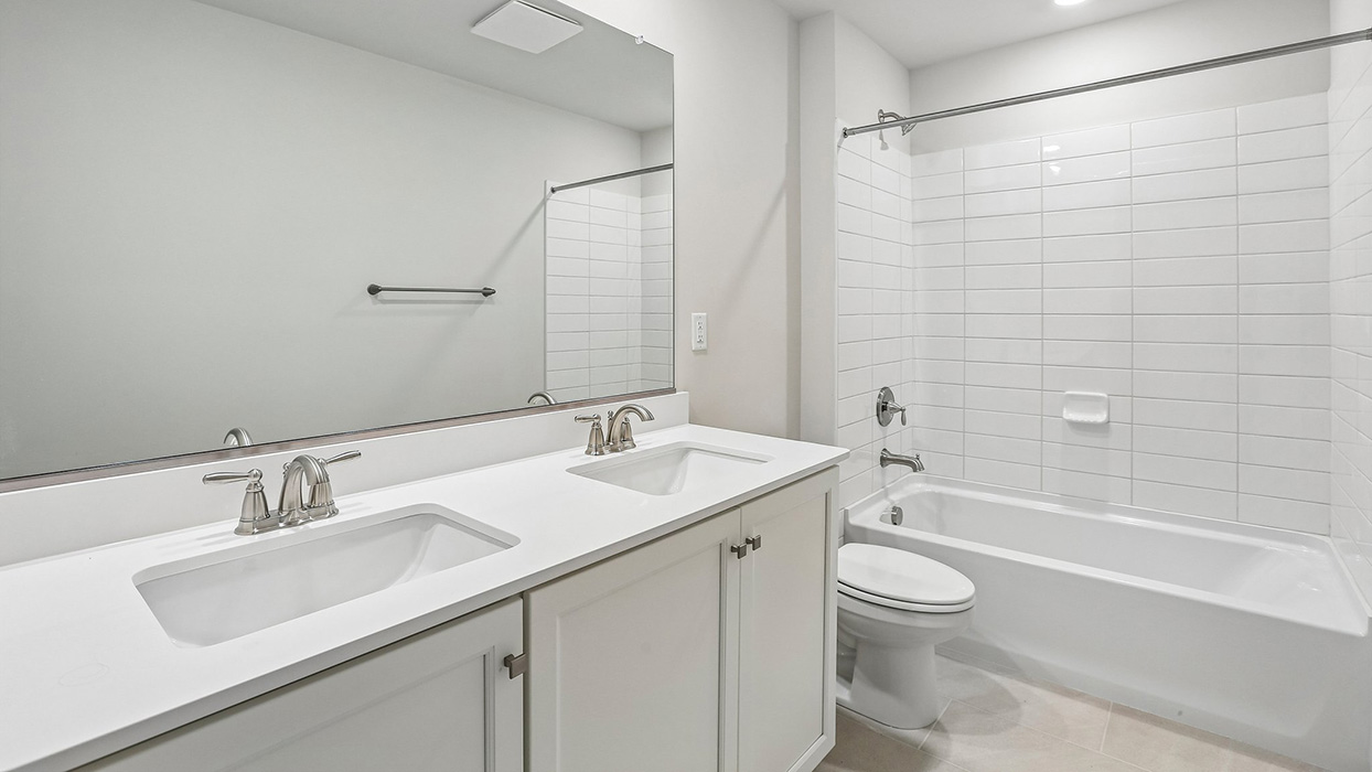 Full bathroom featuring a dual-sink vanity and practical design that supports busy morning routines and everyday convenience.