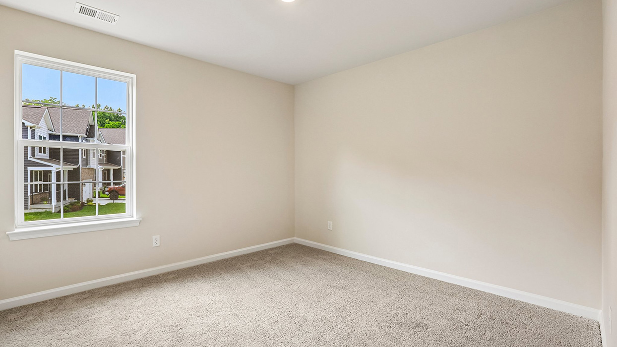 Comfortable secondary bedroom with natural light and flexible space for family members, guests, or a personalized home workspace.