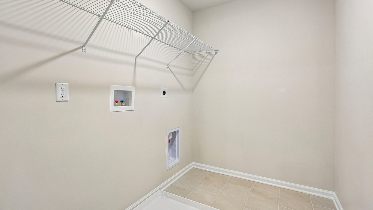 Dedicated laundry room with storage shelving and ample workspace, providing added organization and convenience for daily routines.