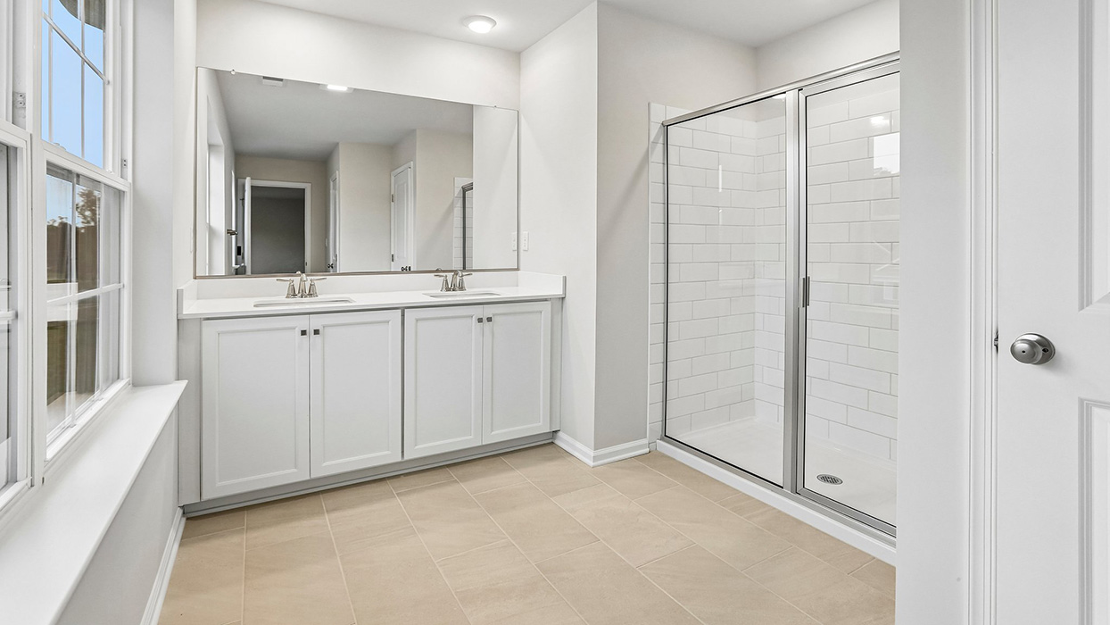 Private primary bathroom featuring a dual-sink vanity, large walk-in shower, and a thoughtfully designed layout that enhances everyday comfort and convenience.